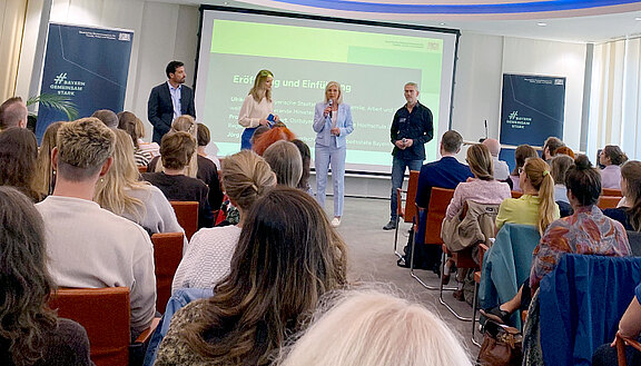 Impressionen vom Fachtag „Jung, radikal, gefährdet?“ Bayerns Sozialministerin Ulrike Scharf begrüßt die Teilnehmenden.