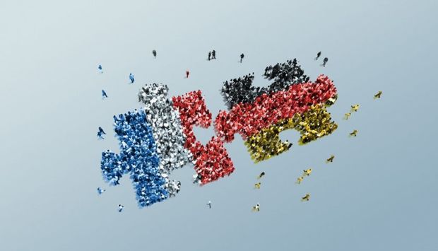 Wei Puzzelteile aus kleinen Menschen vor blauem Hintergrund. Die Menschen der beiden Puzzleteile sind in den Nationalfalggen Frankreichs udn Deutschlands eingefärbt.