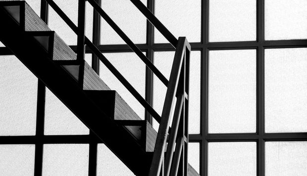 Ein schwarzweiß Foto eines modernen Treppenhauses ohne Menschen im bild.