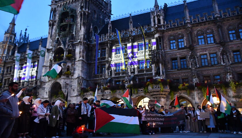 Pro-Palästina-Kundgebung vor dem mit der israelischen Flagge angestrahlten Münchner Rathaus. 