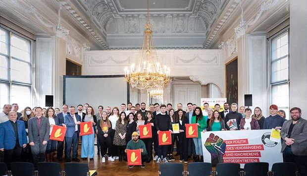 Gruppenbild nach der Verleihung: Die Preisträger:innen mit Redner:innen, darunter auch Bayerns Innenstaatssekretär Sandro Kirchner, und Gästen in der Würzburger Residenz. 